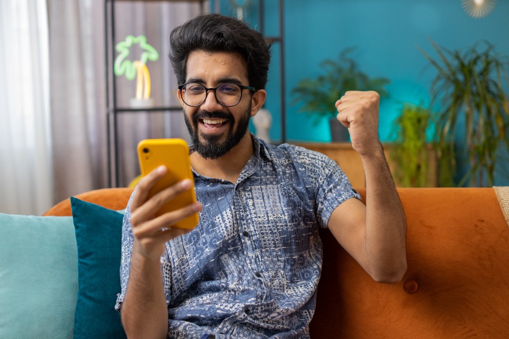 Consumer celebrating a reward win on their phone