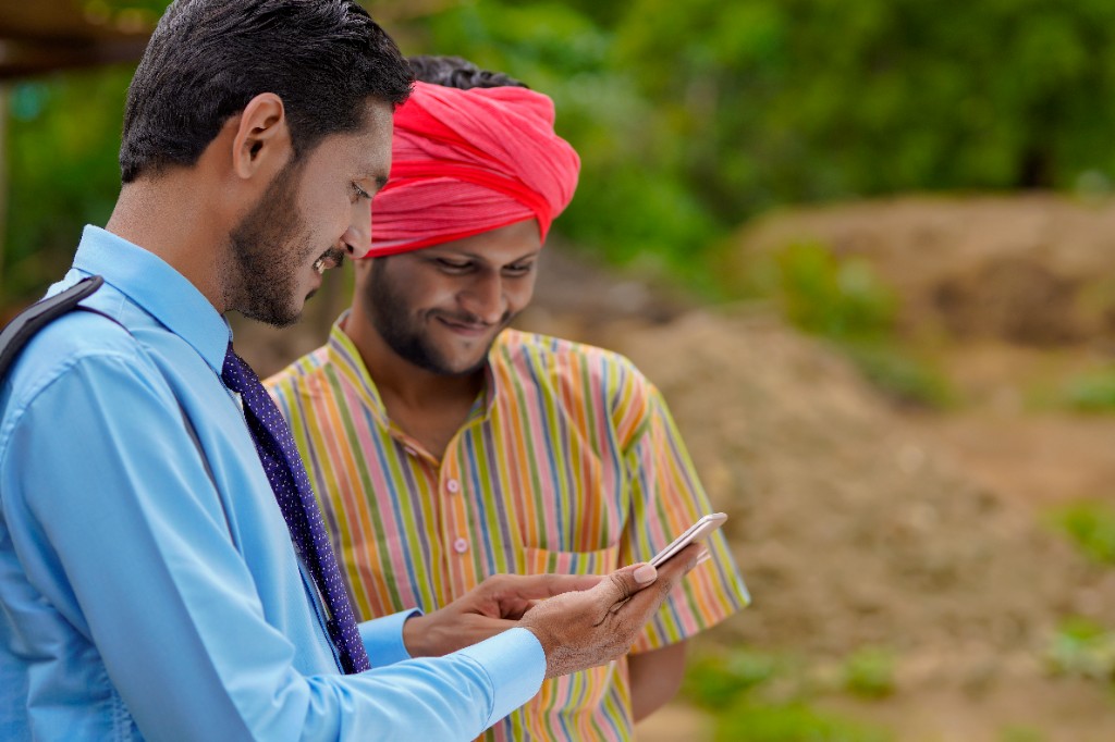 Field agent and rural consumer engaging together on a smartphone